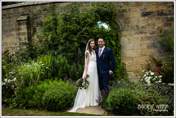 The Bride and Groom pose in the gardens at Chiddingstone Castle