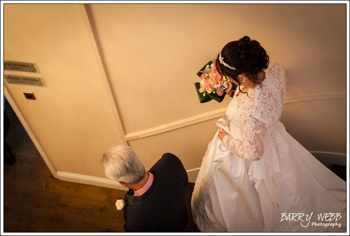 Bride desending the stairs with father at Hadlow Manor Hotel in Kent